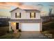 Two-story house with beige vinyl siding, a white garage door, and landscaping at 136 Jo Creek Ln, Harmony, NC 28634