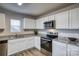 Updated kitchen with white cabinets, granite counters, and stainless steel appliances at 136 Jo Creek Ln, Harmony, NC 28634