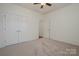 Well-lit bedroom with double doors leading to a closet and ceiling fan at 14509 Batteliere Dr, Charlotte, NC 28278