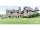 Luxury home with stone exterior, patio, and manicured lawn at 14509 Batteliere Dr, Charlotte, NC 28278