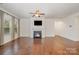 Spacious living room boasting hardwood floors, fireplace, ample natural light, and modern ceiling fan at 14509 Batteliere Dr, Charlotte, NC 28278