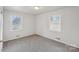 Well-lit bedroom with grey carpet and two windows with blinds at 2016 Norwich Pl, Charlotte, NC 28208