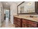 Bathroom boasts granite countertops, wooden cabinetry, and a large framed mirror reflecting a hallway with an open door at 4006 Sincerity Rd, Monroe, NC 28110