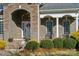 Stone and brick front porch with columns and a white door at 4006 Sincerity Rd, Monroe, NC 28110