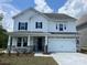Charming two-story home featuring a white exterior, stone accents, a two-car garage, and professionally landscaped front yard at 4050 Caymen Bay Ct, Tega Cay, SC 29708