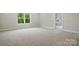 Spacious bedroom with neutral carpet, paint, and trim, and a large window with outdoor views at 5404 Verona Rd # 36, Charlotte, NC 28213