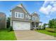 Beautiful two-story home featuring gray siding, a two-car garage, and a lush green lawn at 5404 Verona Rd # 36, Charlotte, NC 28213