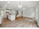 Spacious living area featuring wood floors, recessed lighting, kitchen, stairs and fireplace at 5404 Verona Rd # 36, Charlotte, NC 28213