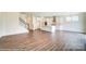 Open-concept living room with wood floors, white trim, and an adjoining kitchen with island at 5404 Verona Rd # 36, Charlotte, NC 28213