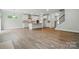 Bright open-concept living room showcasing wood floors, a kitchen island and staircase at 5404 Verona Rd # 36, Charlotte, NC 28213