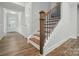 Bright foyer with paneled walls and an open staircase with wood treads and black metal balusters at 5404 Verona Rd # 36, Charlotte, NC 28213