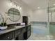 Bathroom featuring modern tiling, vanity with black countertop, and a soaking tub at 5529 Five Knolls Dr, Charlotte, NC 28226