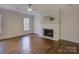 Cozy living room with a white painted brick fireplace and gleaming hardwood floors at 5529 Five Knolls Dr, Charlotte, NC 28226