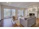 Living room with fireplace, white painted brick, hardwood floors, and sliding doors to backyard at 5529 Five Knolls Dr, Charlotte, NC 28226