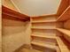 Storage room featuring wooden shelving with neutral patterned wallpaper and wood floor at 5529 Five Knolls Dr, Charlotte, NC 28226