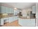 Modern kitchen with light-blue cabinets, granite countertops, and tile backsplash at 6415 Outer Bridge Ln, Charlotte, NC 28270