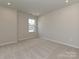 An empty bedroom features a neutral color scheme and carpeted flooring at 8022 Franklin Trail St, Mint Hill, NC 28227