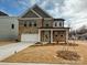 Traditional two-story brick home with a two-car garage and covered front porch at 8022 Franklin Trail St, Mint Hill, NC 28227