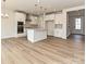 Open-concept kitchen features white cabinets, stainless appliances and hardwood flooring at 8022 Franklin Trail St, Mint Hill, NC 28227