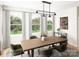 Bright dining room with wood table, green chairs, and large windows overlooking a garden at 8026 Cedarsmith Ct, Charlotte, NC 28217