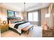 Spacious main bedroom with a large bed, neutral decor, and an orange bench at 8026 Cedarsmith Ct, Charlotte, NC 28217