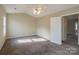 Well-lit bedroom with carpet flooring and a door to another room at 13406 Tartarian Ct, Charlotte, NC 28215