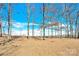 Wooded lot with tall, bare trees and a bright blue sky at 2108 Sherwood Forest Ln, Monroe, NC 28110