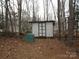 This outbuilding features double doors, a white roof, and is surrounded by trees and leaves at 3958 Benny Shrum Ln, Maiden, NC 28650