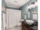 Bathroom with dark vanity, vessel sink, and white shower curtain at 509 N Graham St # 1G, Charlotte, NC 28202