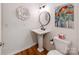 Stylish powder room featuring a pedestal sink, wood-look floors, and framed art at 509 N Graham St # 1G, Charlotte, NC 28202