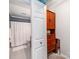 Small bathroom with a toilet, shower, and built-in wooden cabinet at 509 N Graham St # 1G, Charlotte, NC 28202