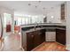 Eat-in kitchen with dark cabinetry, stainless steel dishwasher, and views into the living room at 509 N Graham St # 1G, Charlotte, NC 28202