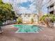 Community pool with brick patio and surrounding buildings at 509 N Graham St # 1G, Charlotte, NC 28202