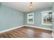 Light-filled bedroom with two windows, hardwood floors, and modern light fixture at 5204 Dellinger Cir, Cherryville, NC 28021