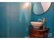 Stylish powder room with a pedestal sink and teal walls at 6132 Pale Moss Ln, Charlotte, NC 28269