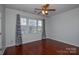 Bedroom with hardwood floors, window with blinds and ceiling fan at 6132 Pale Moss Ln, Charlotte, NC 28269