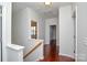 Upstairs hallway with hardwood floors and access to bedrooms at 6132 Pale Moss Ln, Charlotte, NC 28269