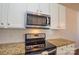 Stainless steel microwave and range complement the granite countertops at 6132 Pale Moss Ln, Charlotte, NC 28269