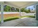 View of covered back patio and fenced backyard with green grass and landscaped hill at 8230 Verona Rd # 80, Charlotte, NC 28213