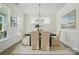 Well-lit dining room with light colored walls, a modern chandelier, and large windows at 8230 Verona Rd # 80, Charlotte, NC 28213