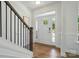Bright foyer with hardwood floors, staircase with dark metal railings, and natural light at 8230 Verona Rd # 80, Charlotte, NC 28213