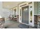 Cozy covered front porch with stone pillars, seating area, and a stylish front door at 8230 Verona Rd # 80, Charlotte, NC 28213