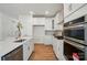Bright white kitchen with stainless steel appliances, hardwood floors, and modern white cabinets at 8230 Verona Rd # 80, Charlotte, NC 28213
