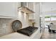 This kitchen features white subway tile backsplash, stainless vent hood, and gas cooktop at 8230 Verona Rd # 80, Charlotte, NC 28213