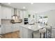 Open kitchen featuring white cabinets, stainless steel appliances, quartz island and seating for entertaining at 8230 Verona Rd # 80, Charlotte, NC 28213