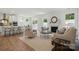 Open-concept living room with a fireplace, hardwood floors, and plenty of seating at 8230 Verona Rd # 80, Charlotte, NC 28213
