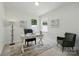 Bright home office featuring a light-colored desk, modern decor, and a cozy green accent chair at 8230 Verona Rd # 80, Charlotte, NC 28213