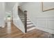 Elegant staircase with wood treads, white risers, and a dark wood railing at 8230 Verona Rd # 80, Charlotte, NC 28213