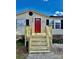 Mobile home with a red door and new wooden stairs at 9763 Knightbridge Dr, Concord, NC 28025