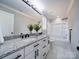 Stylish bathroom featuring dual sinks, granite countertops, modern fixtures, and a tub with a shower at 4739 Whispering Oaks Dr, Charlotte, NC 28213